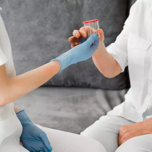 врач дает баночку для анализа кала